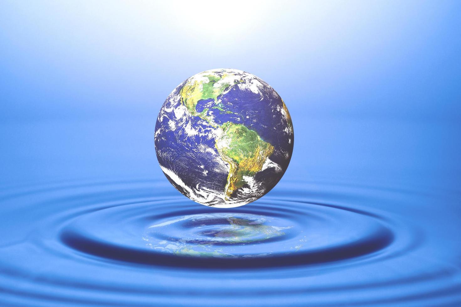 concept mondial et ressources en eau, gestion de l'eau. globe flottant sur l'eau photo