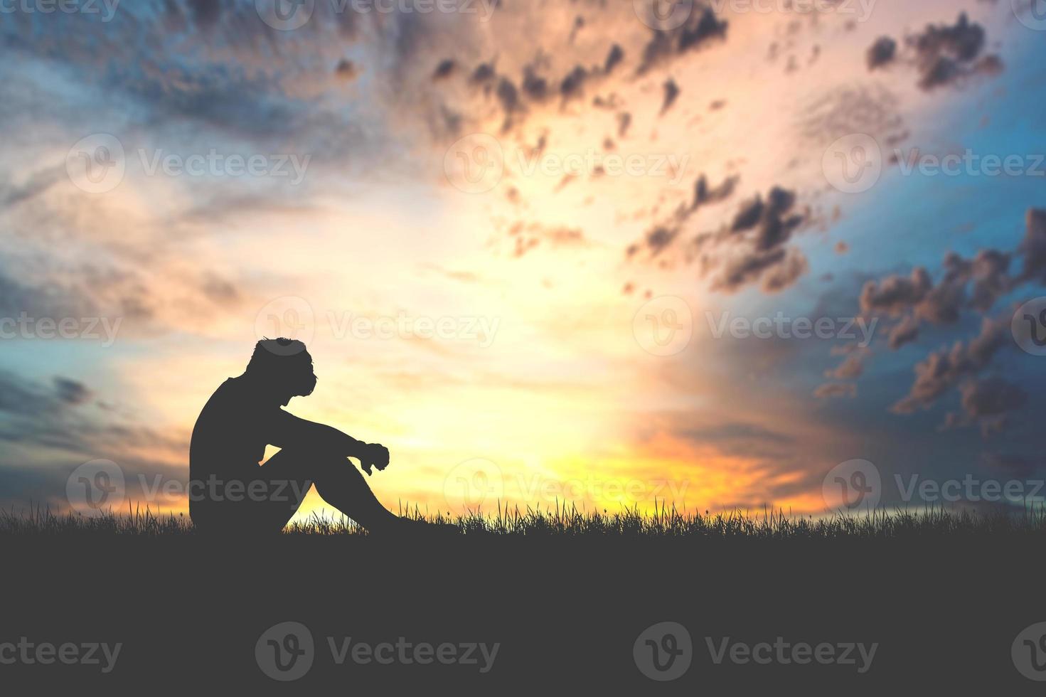 le concept de désespoir, de découragement et de solitude. silhouettes de personnes assises la tête baissée dans le chagrin dans les prés. photo