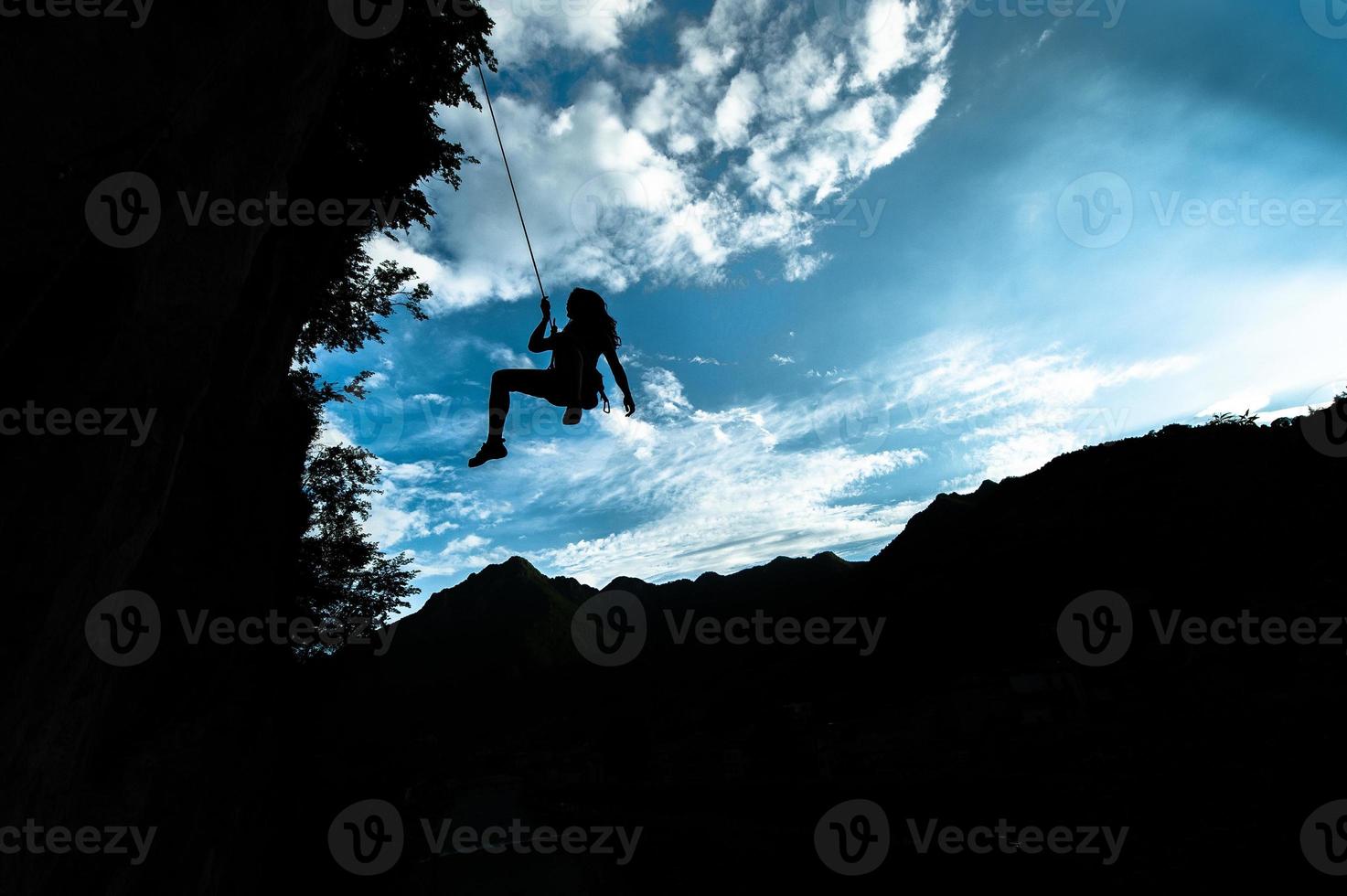 silhouette d'une fille descendant de la corde après avoir grimpé photo