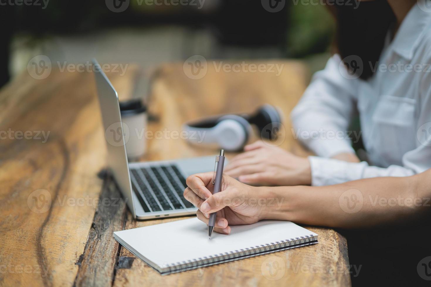 un homme d'affaires utilise un stylo pour un ordinateur portable et des collègues de femme d'affaires travaillant avec un ordinateur portable ensemble dans un café moderne. des partenaires commerciaux discutant d'un nouveau projet de démarrage. photo