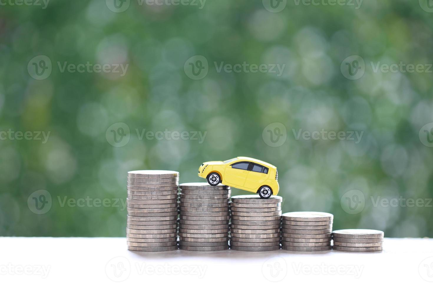 modèle de voiture miniature sur une pile croissante de pièces d'argent sur fond vert nature, économiser de l'argent pour la voiture, la finance et le prêt automobile, l'investissement et le concept d'entreprise photo