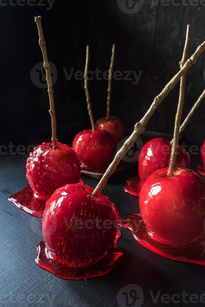 pomme bonbon halloween avec bâton d'or sur fond sombre photo