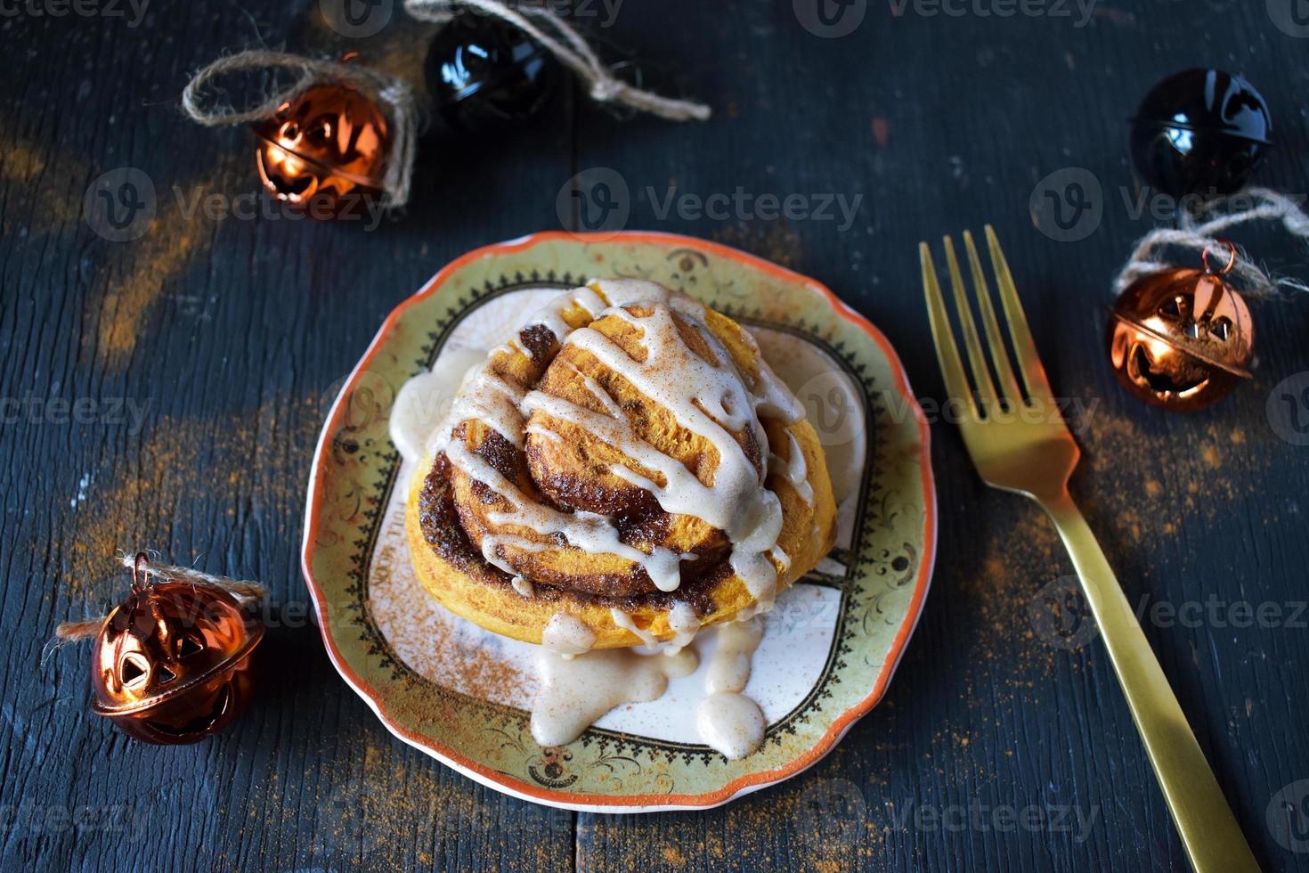 Assiette de brioche à la cannelle citrouille halloween dégoulinant de glaçage blanc photo