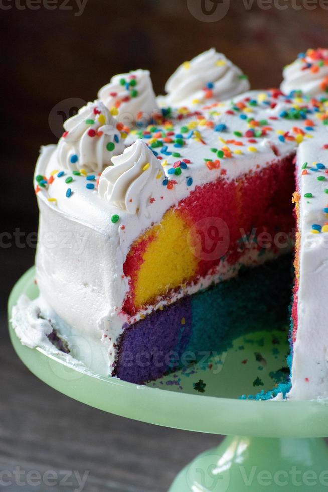 tranche de gâteau arc-en-ciel heureux avec glaçage blanc et pépites photo