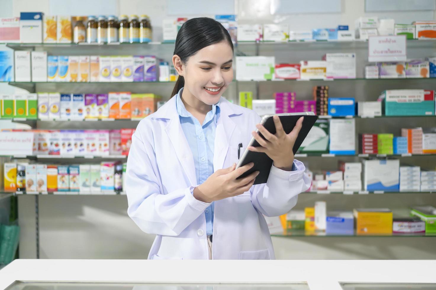 portrait d'une pharmacienne à l'aide d'une tablette dans une pharmacie de pharmacie moderne. photo