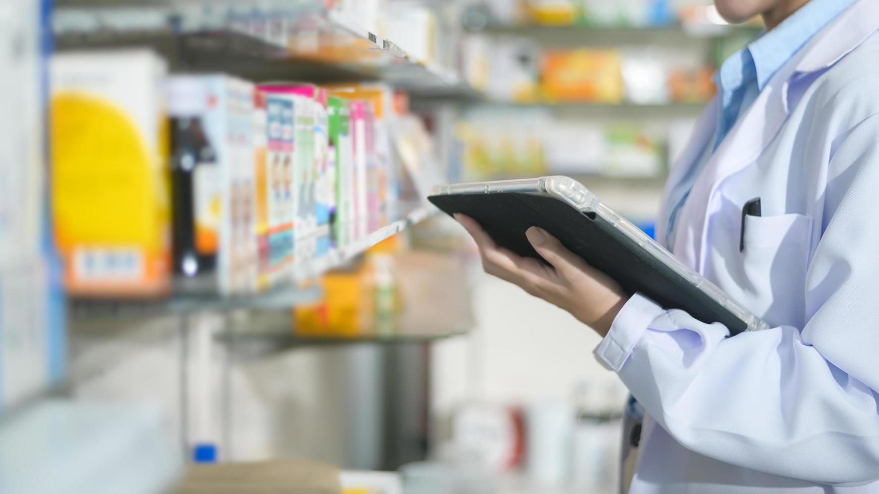 portrait d'une pharmacienne à l'aide d'une tablette dans une pharmacie de pharmacie moderne. photo