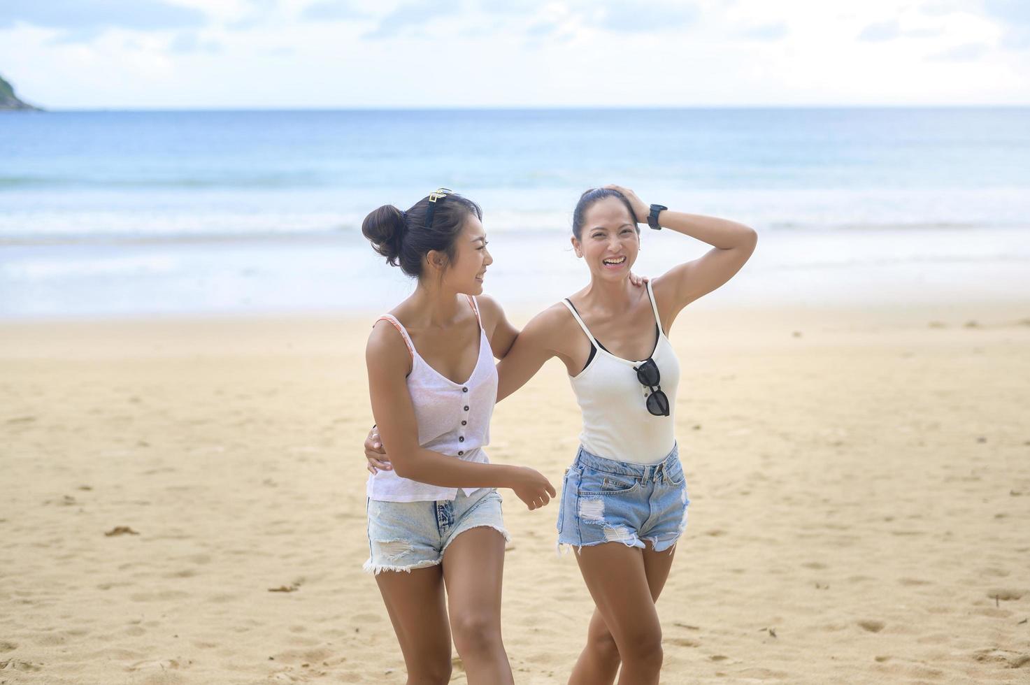 deux jolies amies appréciant et se relaxant sur la plage, l'été, les vacances, les vacances, le concept de modes de vie. photo