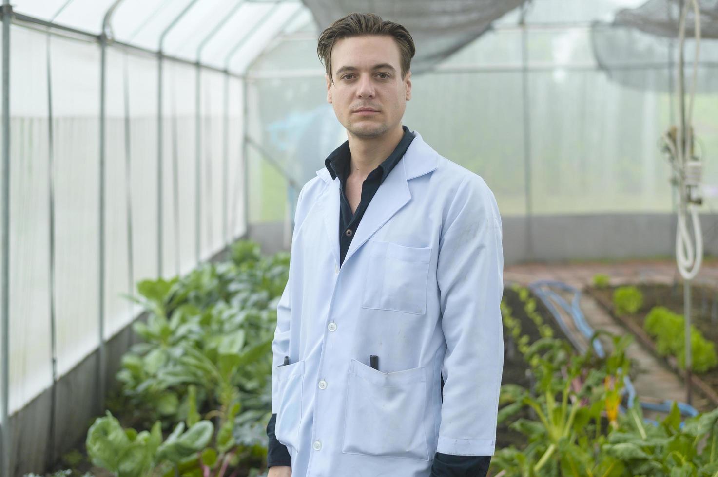 un homme scientifique analyse des plantes de légumes biologiques en serre, concept de technologie agricole photo