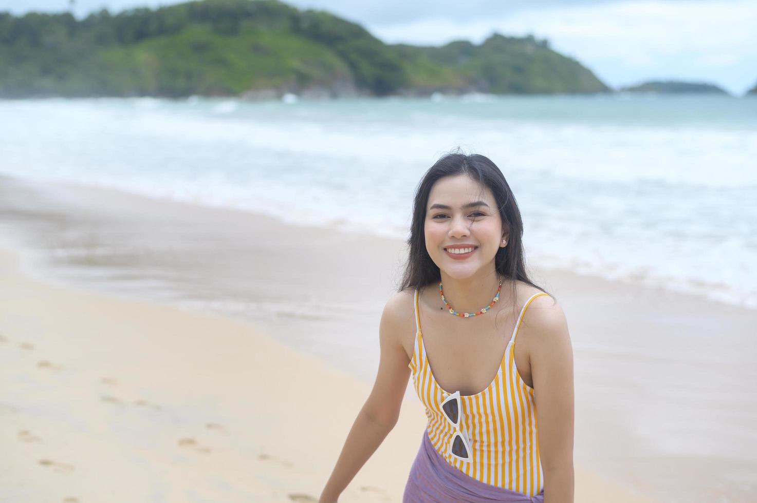 belle jeune femme en bikini profitant et se relaxant sur la plage, l'été, les vacances, les vacances, le concept de modes de vie. photo