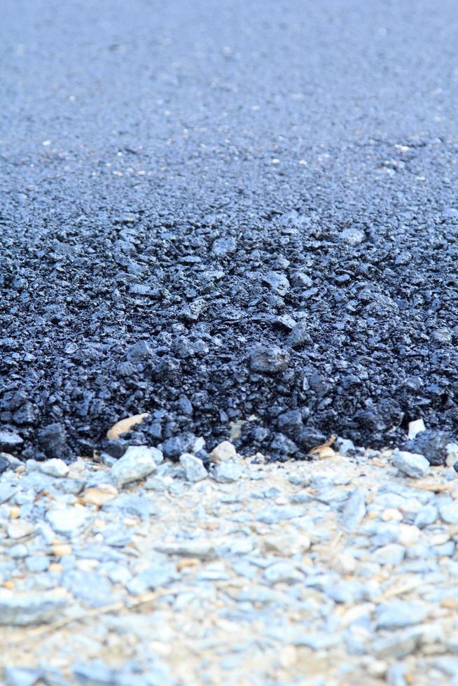 la surface de la route asphaltée en construction a des joints de gravier, avec un fond noir et gris comme image verticale et horizontale. photo