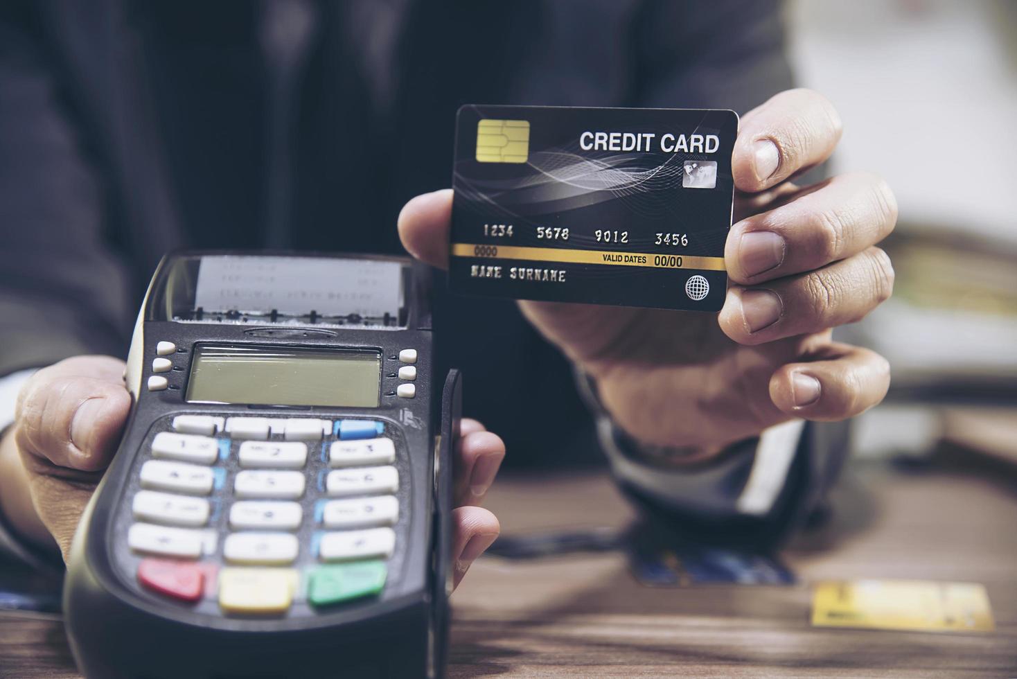 la main d'un marchand à l'aide d'une machine à carte de crédit photo