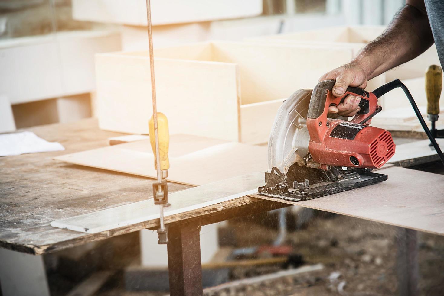 menuisier travaillant avec la préparation de produits de meubles en bois tout en coupant une planche de bois avec une scie circulaire photo