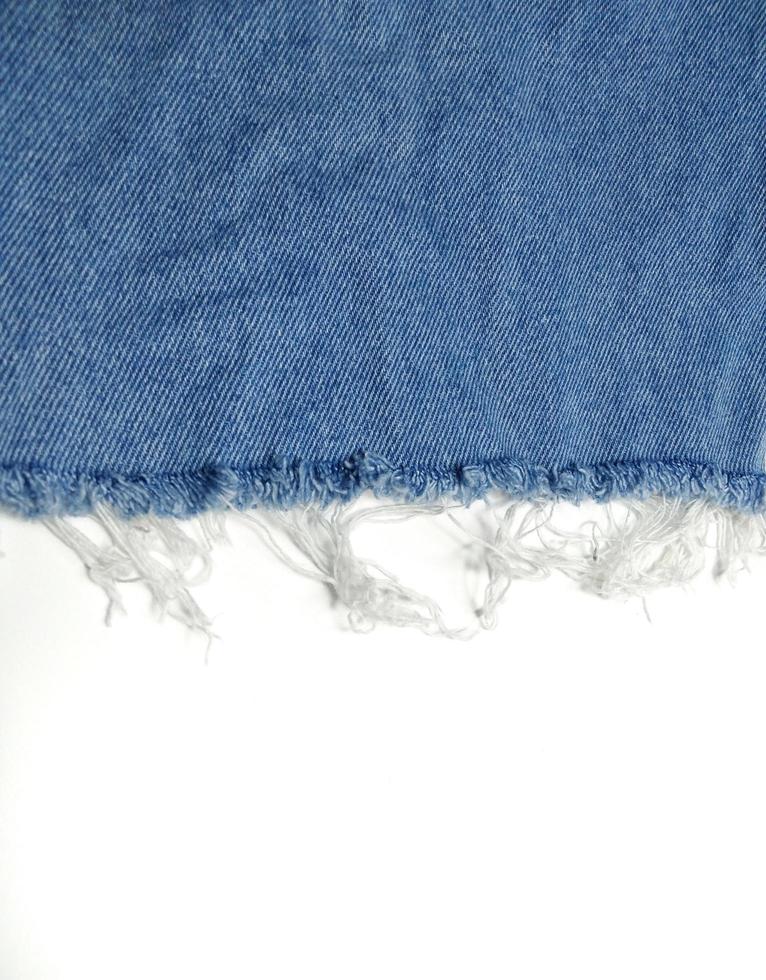 la texture bleu jean a une déchirure, voir le tissu blanc à l'intérieur. donnant une nouvelle perspective qui n'a jamais été vue espace de copie de fond blanc photo