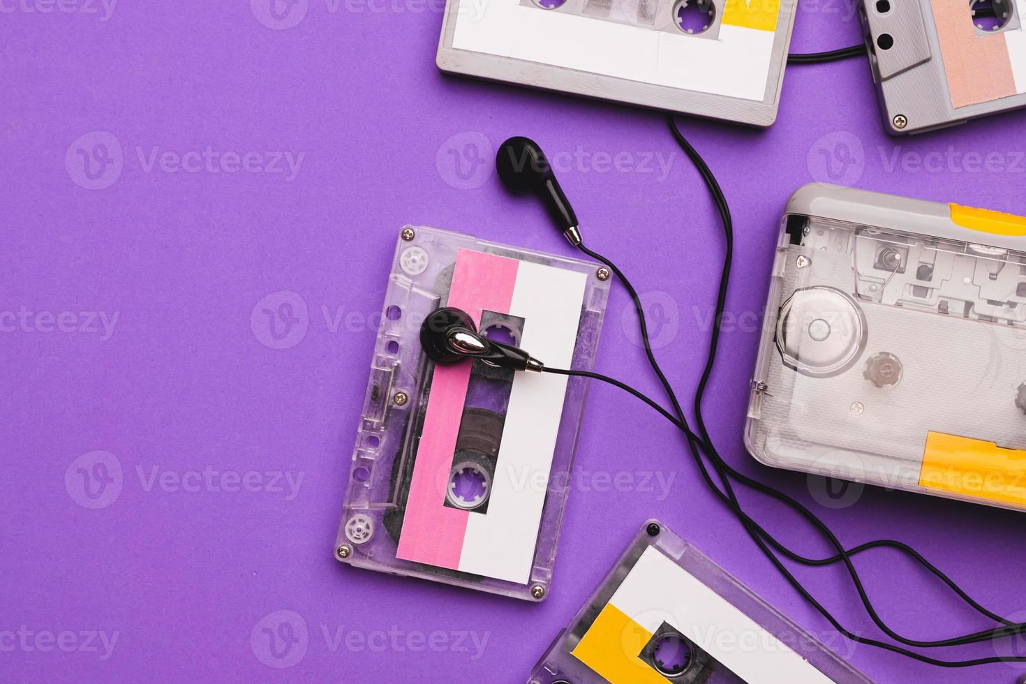 lecteur de cassettes avec écouteurs et cassettes sur fond violet. photo