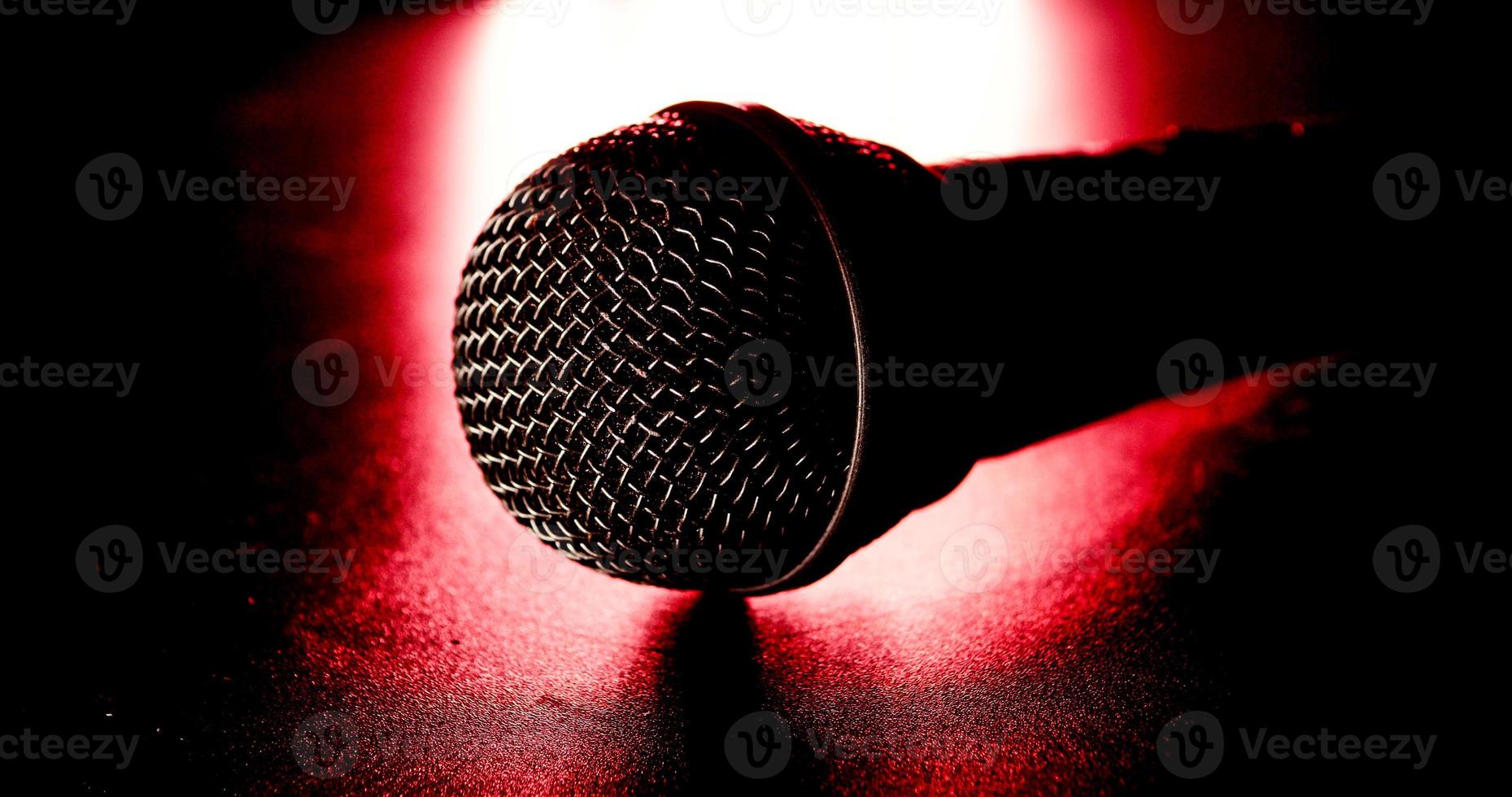 gros plan d'un microphone noir sur fond rouge et noir. photo