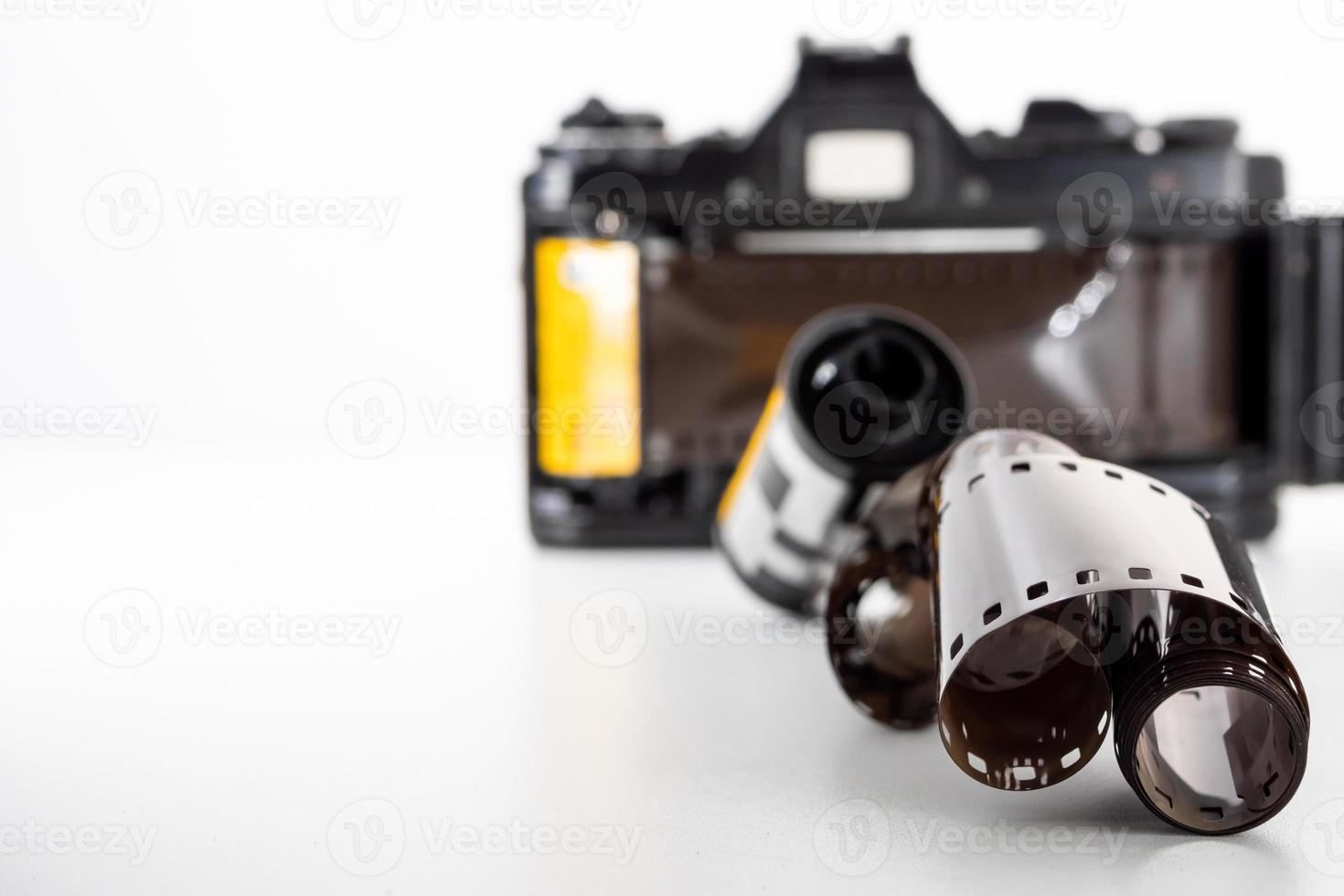 appareil photo reflex à objectif unique et un rouleau de film sur un fond blanc.