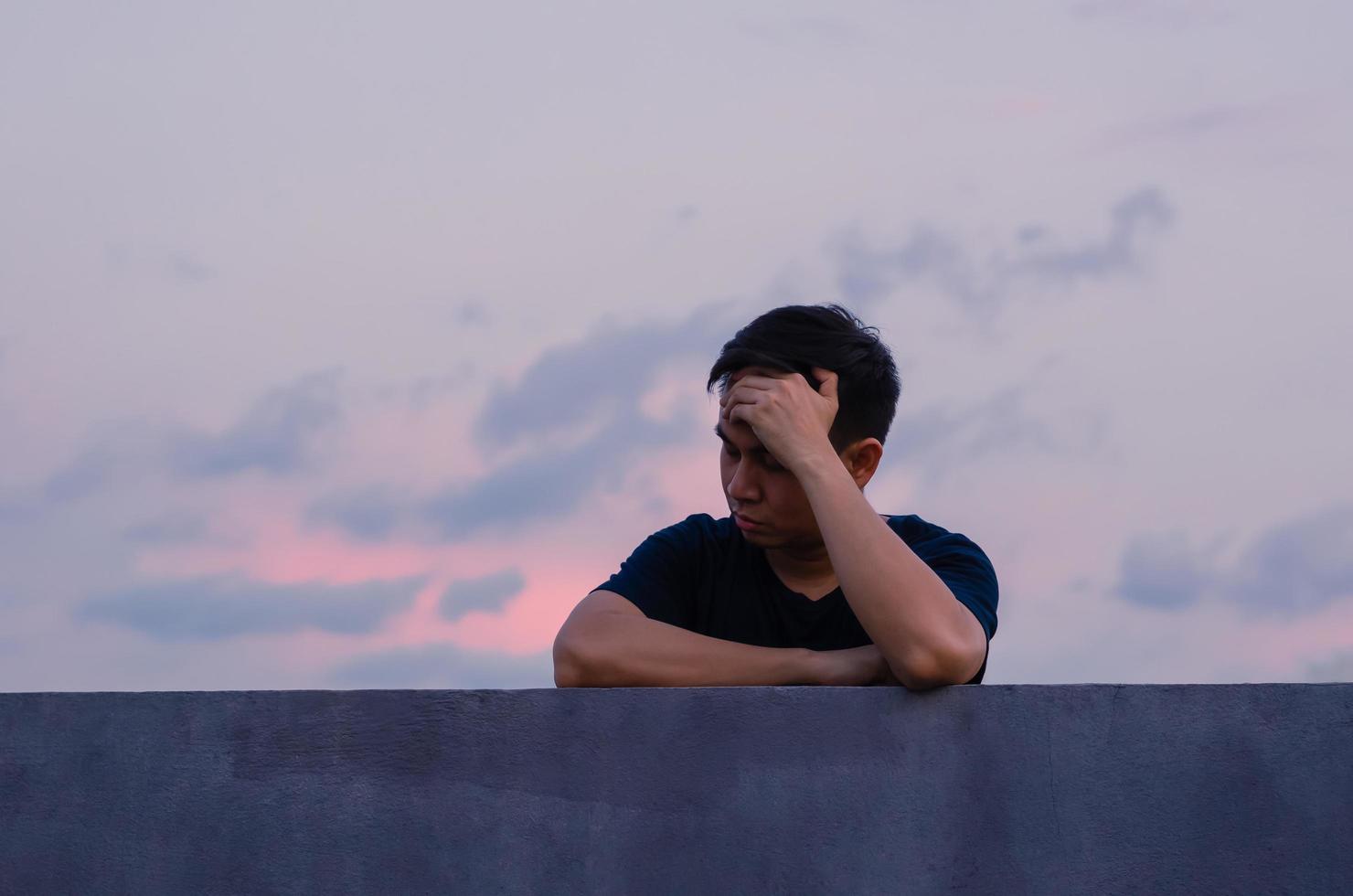 l'homme déprimé misérable asiatique reste seul avec fond de ciel. concept de dépression et de santé mentale. photo