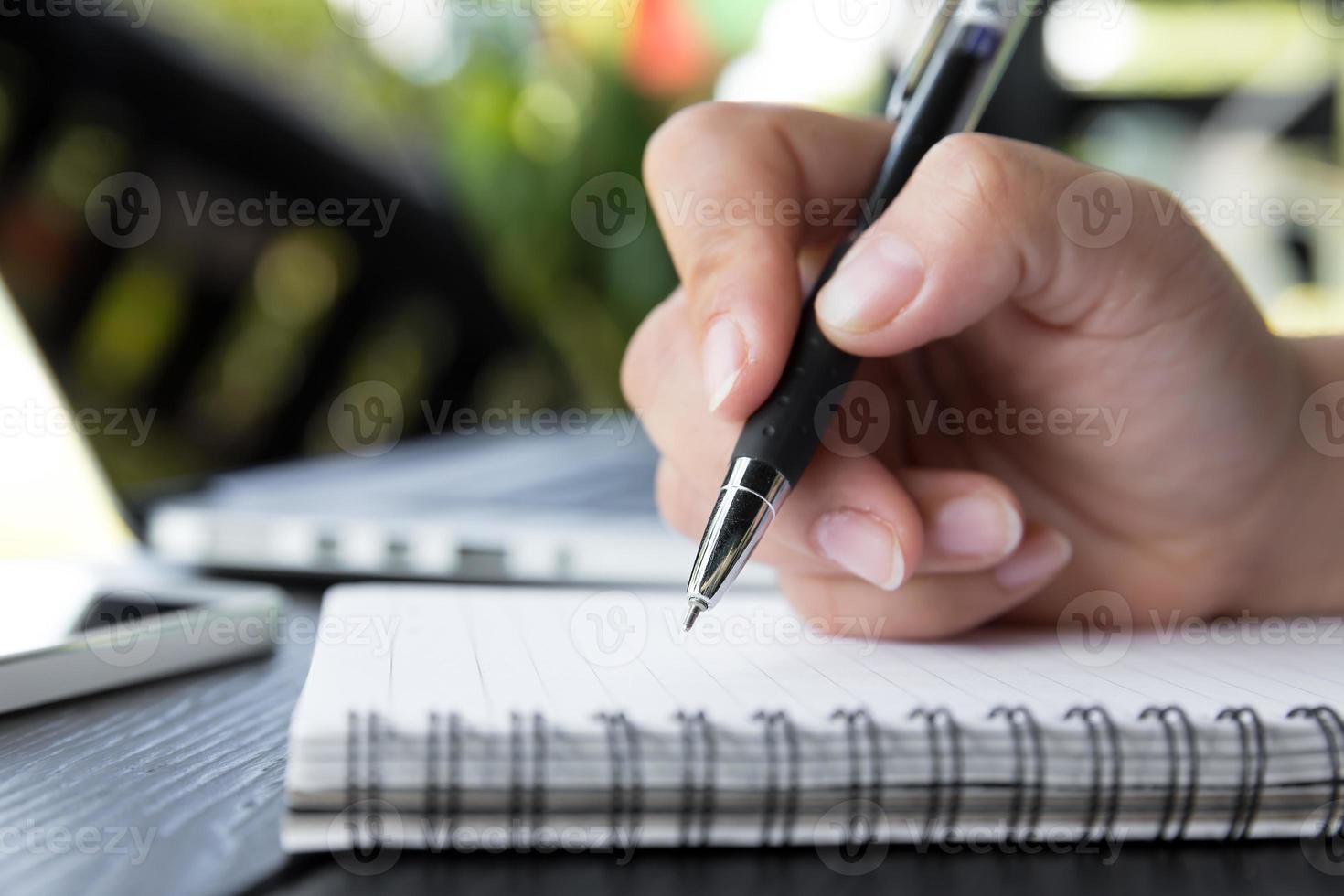 main tenir un stylo écrit sur le cahier photo