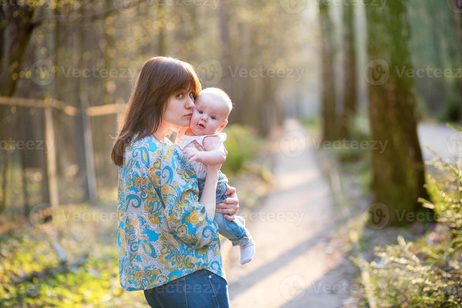 jeune maman avec son petit bébé dans la forêt photo