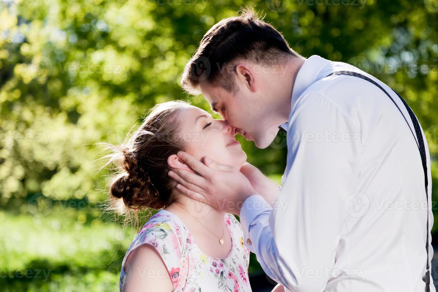 jeune couple romantique s'embrassant avec amour dans le parc d'été. photo