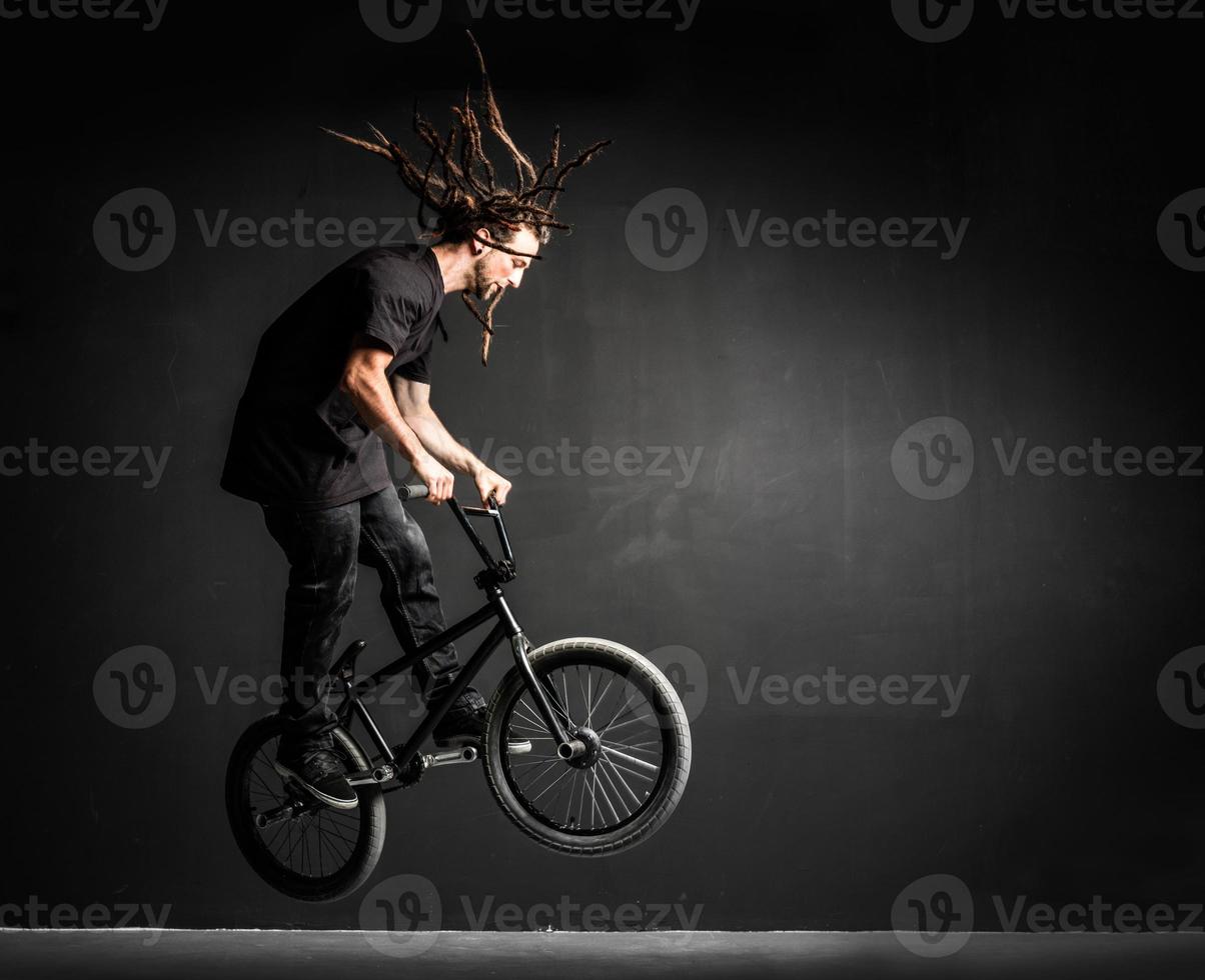 jeune sportif faisant des cascades sur son vélo professionnel. photo