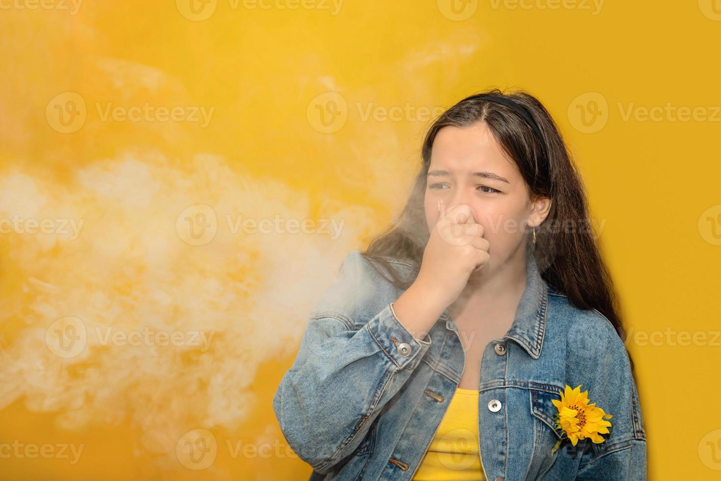 une adolescente se pince le nez parce que les vapeurs toxiques de la voiture, la mauvaise odeur, la pollution de l'air, les allergies à la poussière ou l'infection des sinus, les adolescentes qui se frottent le nez souffrent d'allergies en ville, la vie des citadins. photo