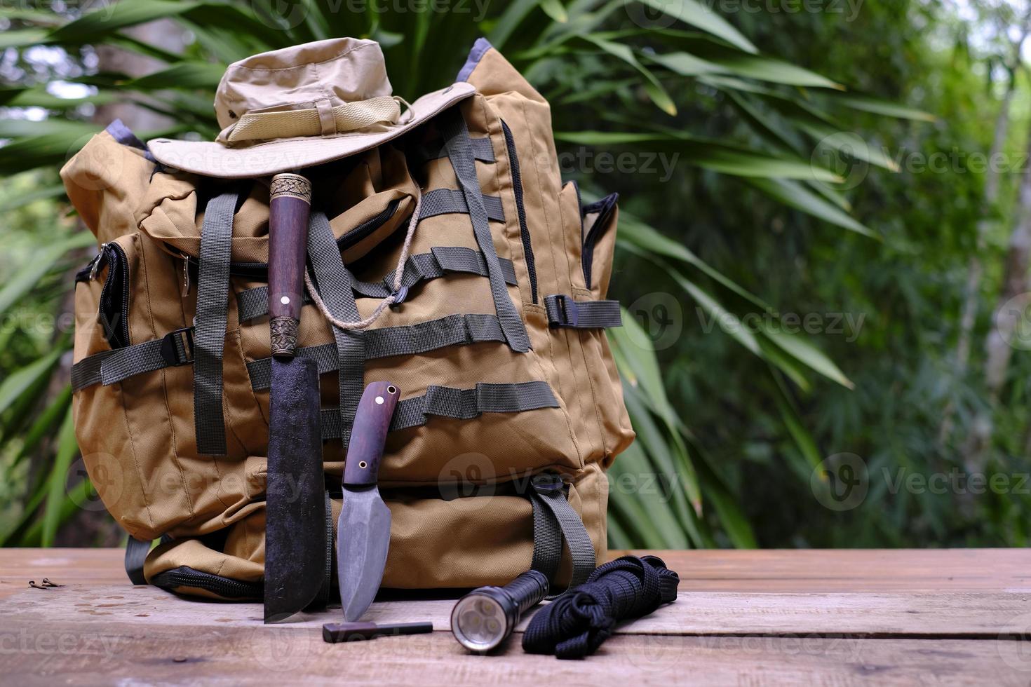 un couteau avec équipement de survie dans la forêt sur un vieux plancher en bois photo