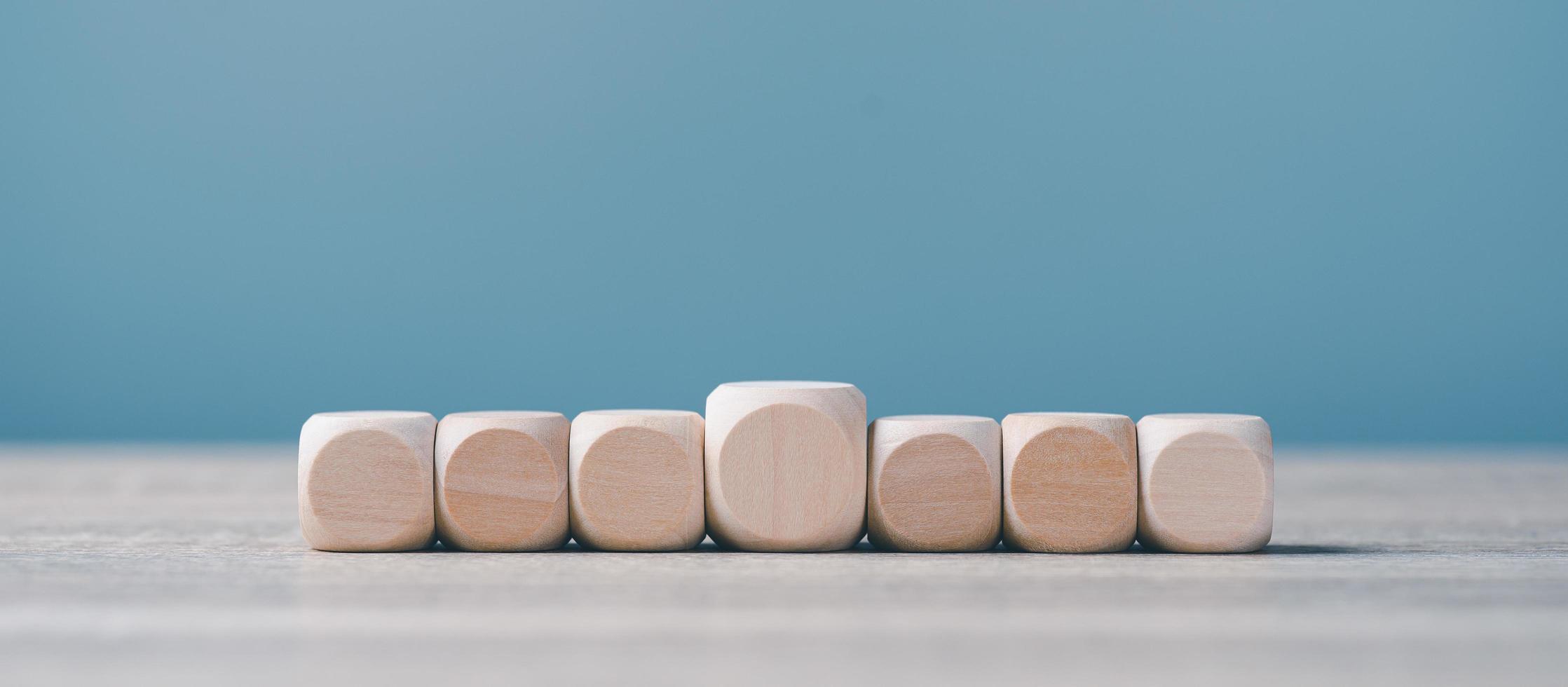 blocs de bois carrés alignés sur un établi en bois. photo