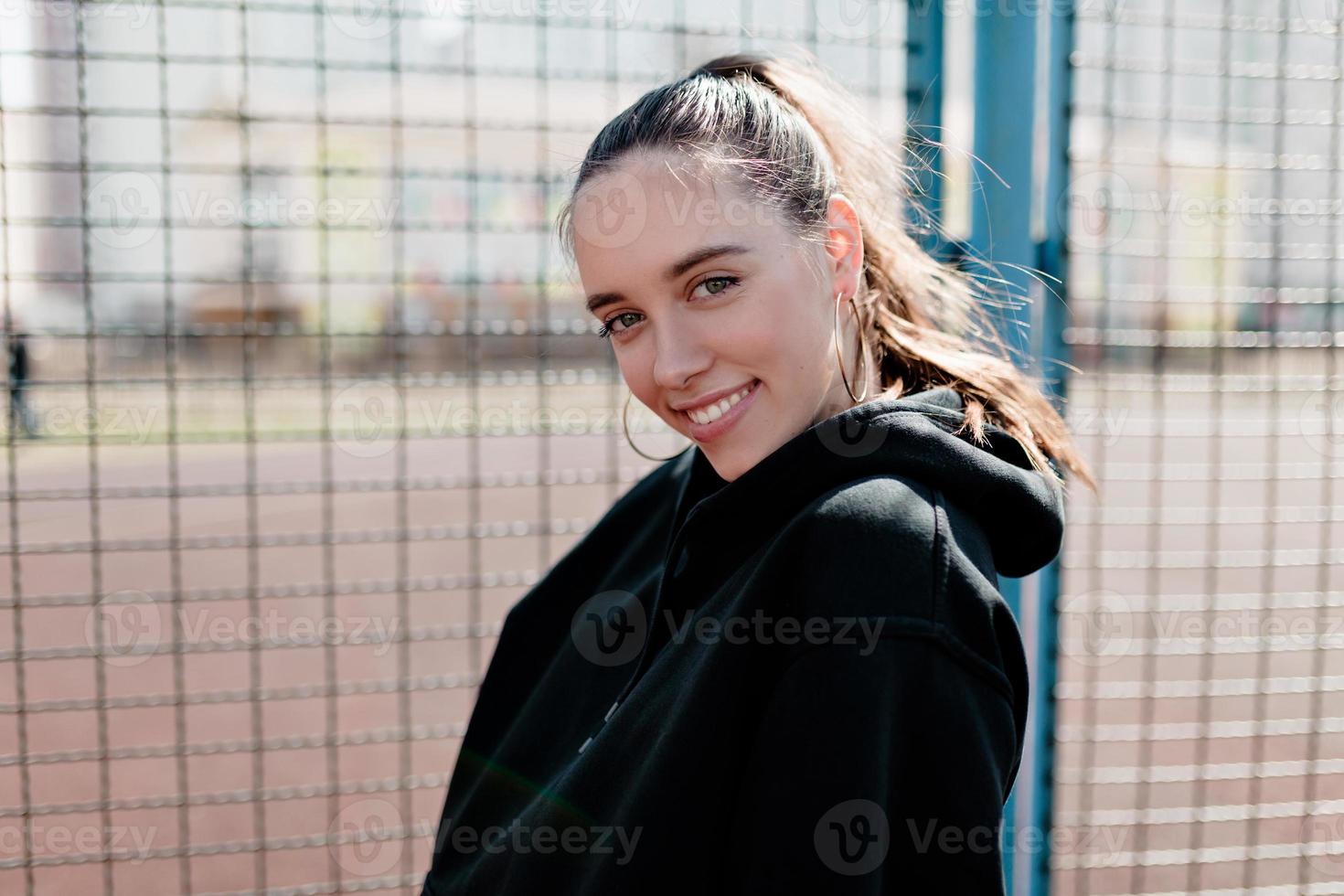 jolie jolie femme souriante posant à la caméra avec un sourire heureux posant à la caméra sur fond flou dans la ville photo