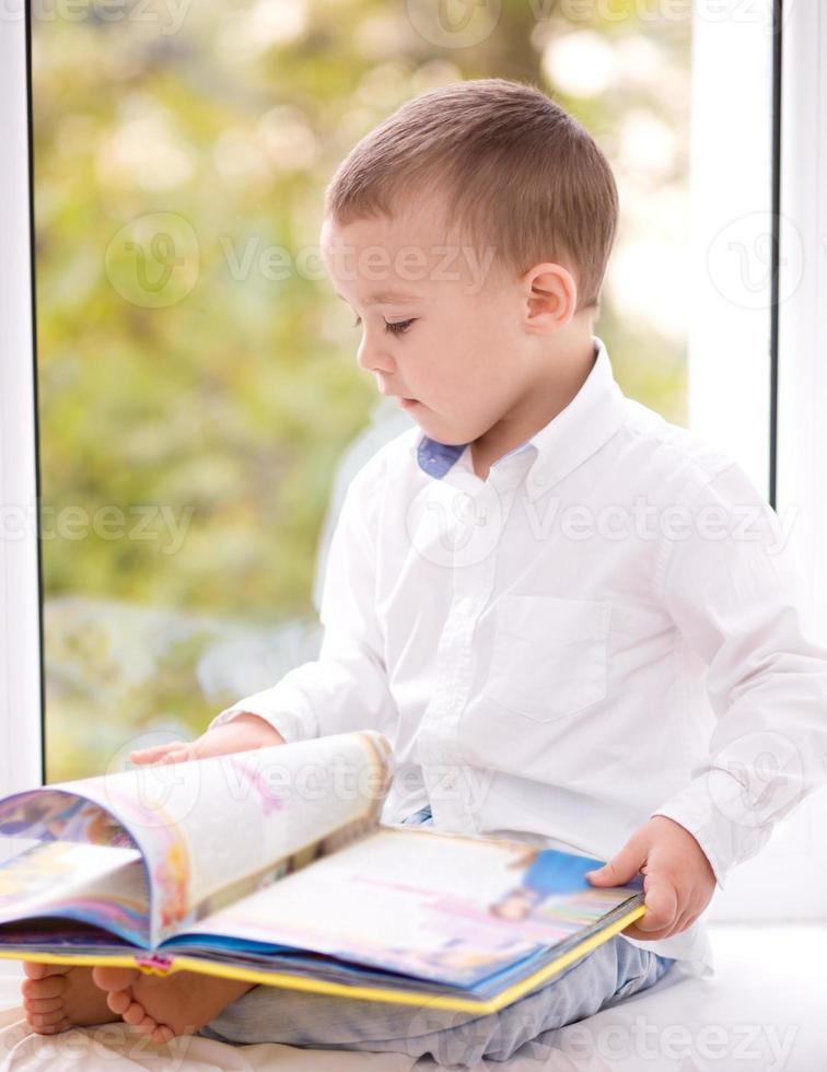 petit garçon lit un livre photo