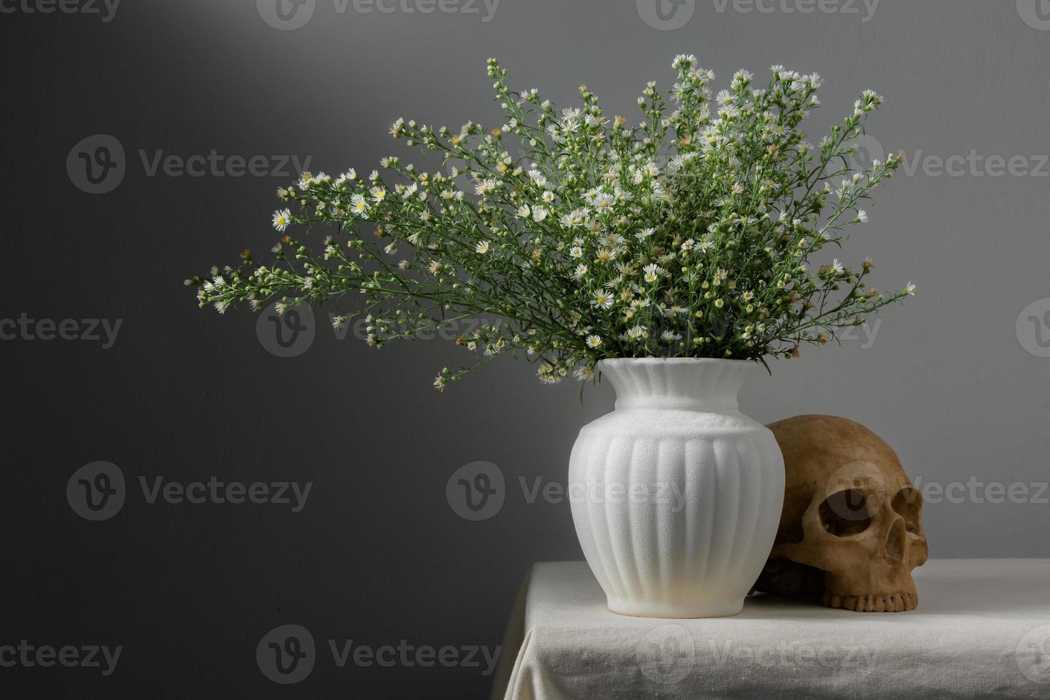 nature morte avec des fleurs dans un vase et un crâne photo