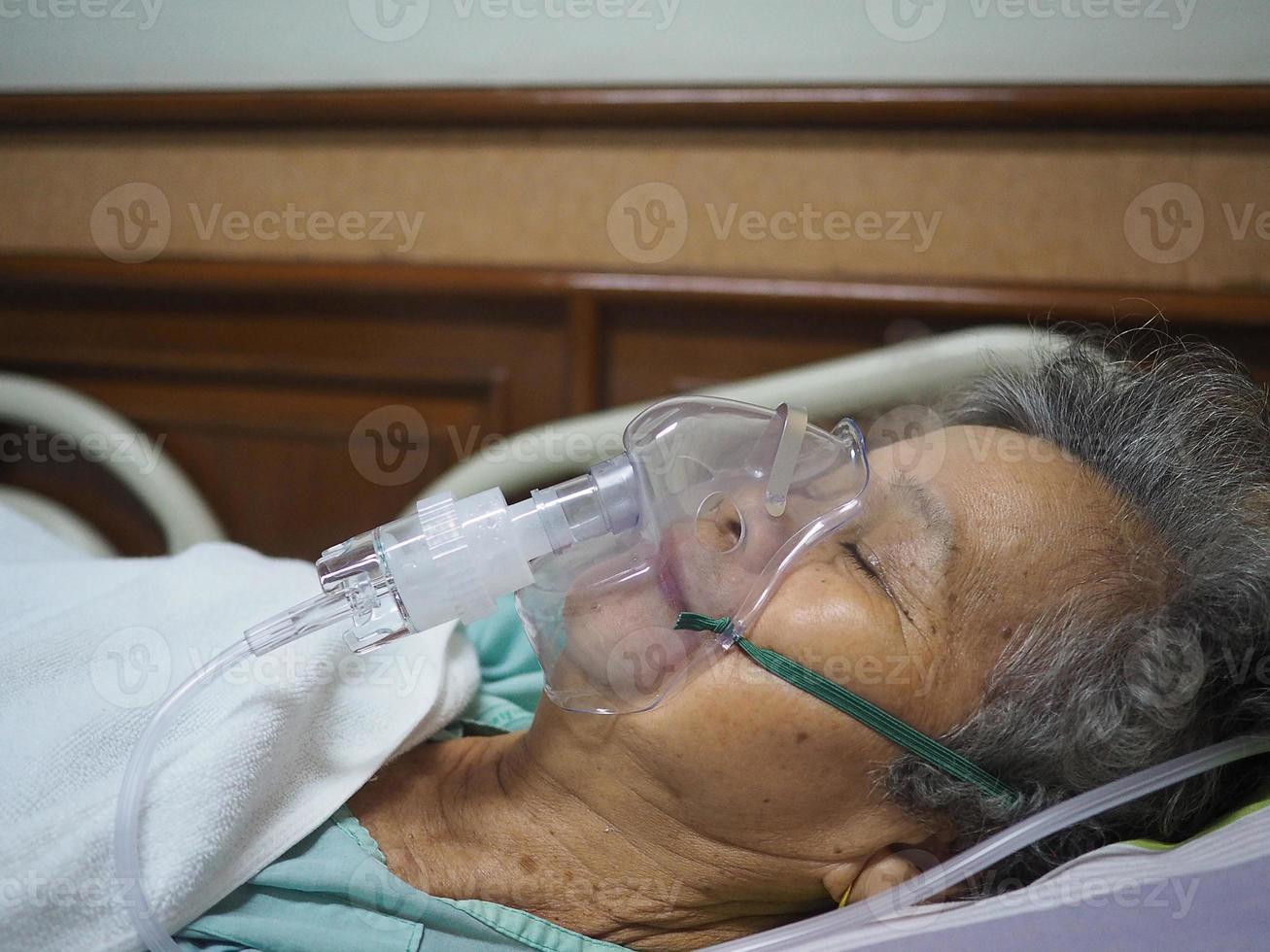 une femme âgée souffre d'asthme et a besoin d'une nébulisation, d'une thérapie par inhalation par le masque de l'inhalateur photo