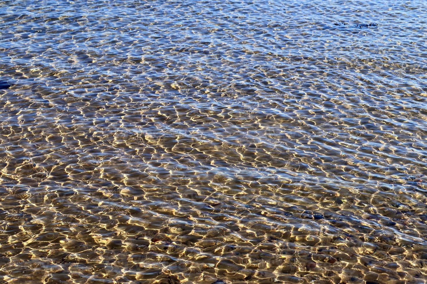 vue rapprochée détaillée sur les surfaces de l'eau avec des ondulations et des vagues et la lumière du soleil se reflétant à la surface photo