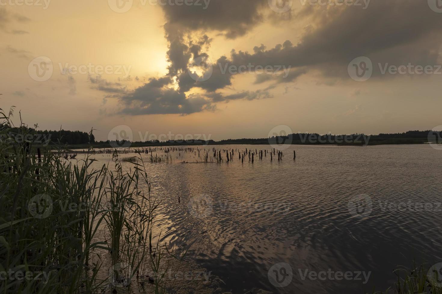 lac au coucher du soleil avec ciel orange jaune photo