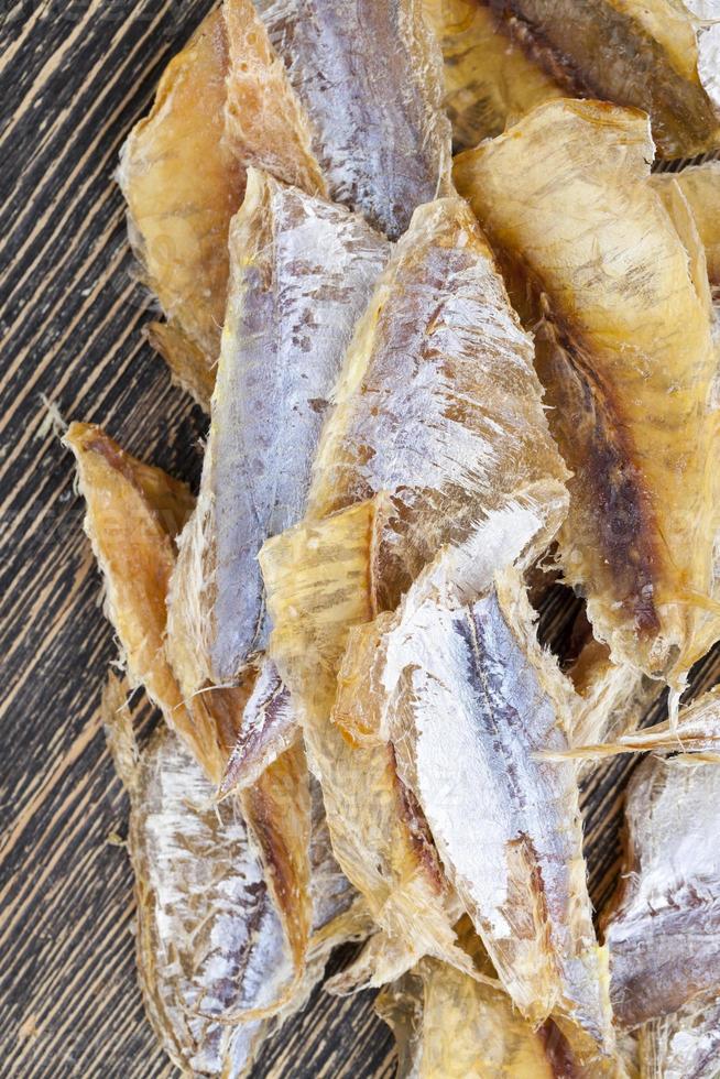 petits poissons séchés et dépecés sur une table en bois photo