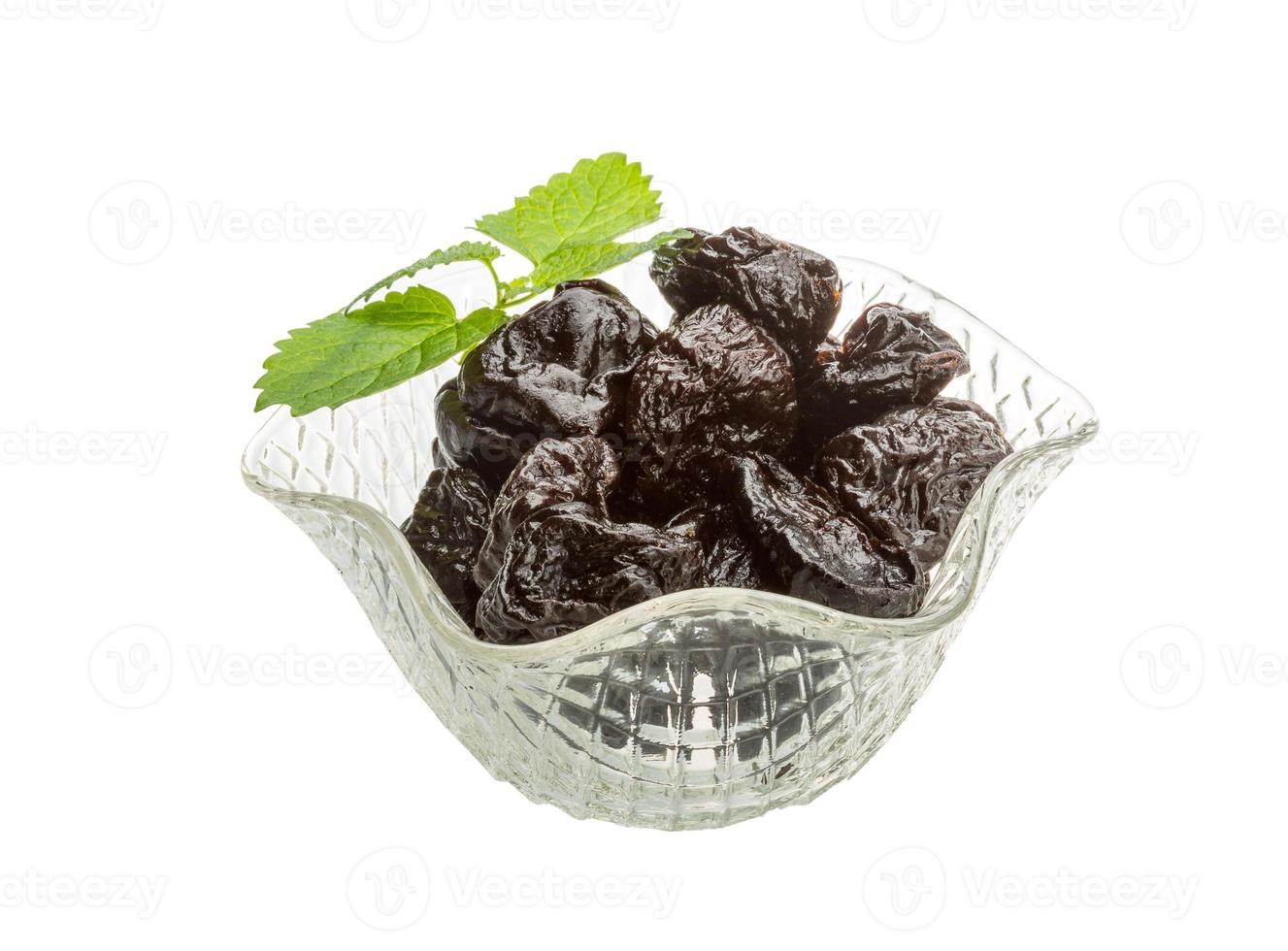 prunes séchées dans un bol sur fond blanc photo