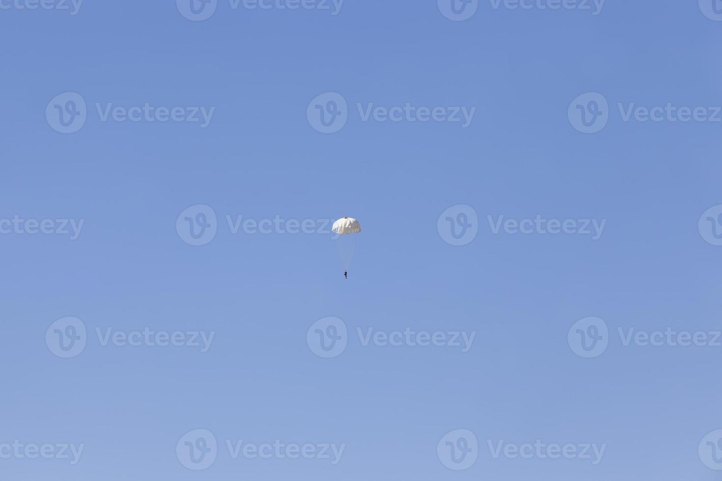 un parachutiste descendant dans le ciel bleu photo