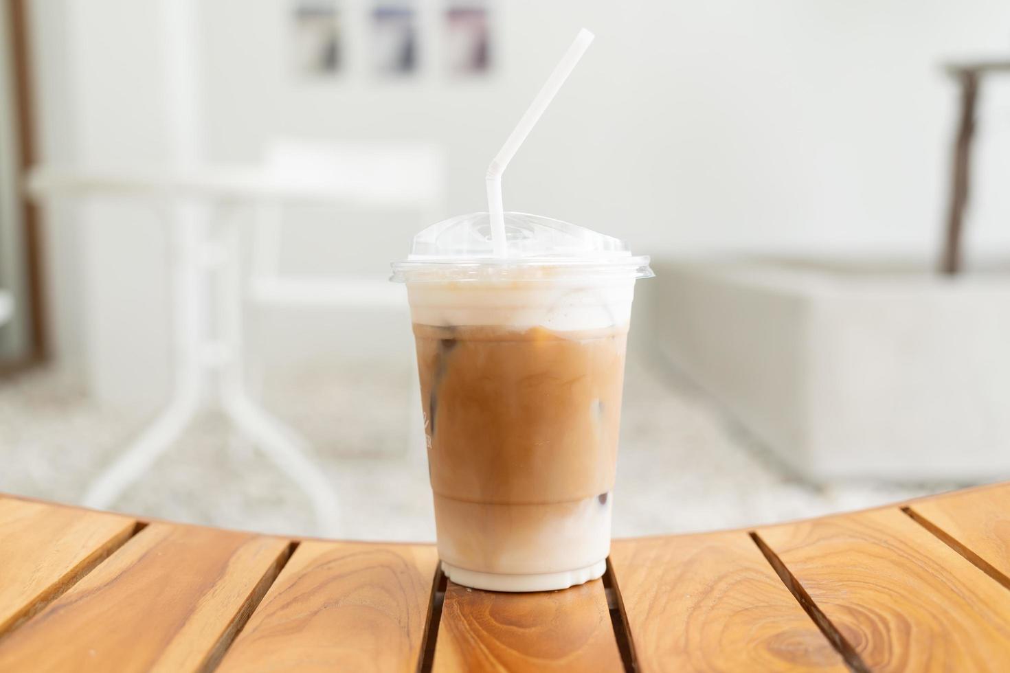 café frais, cappuccino glacé, macchiato, latte avec lait et café séparés. café dans une tasse en plastique sur une table en bois. Tasse à café glacée en plastique sur table en bois photo