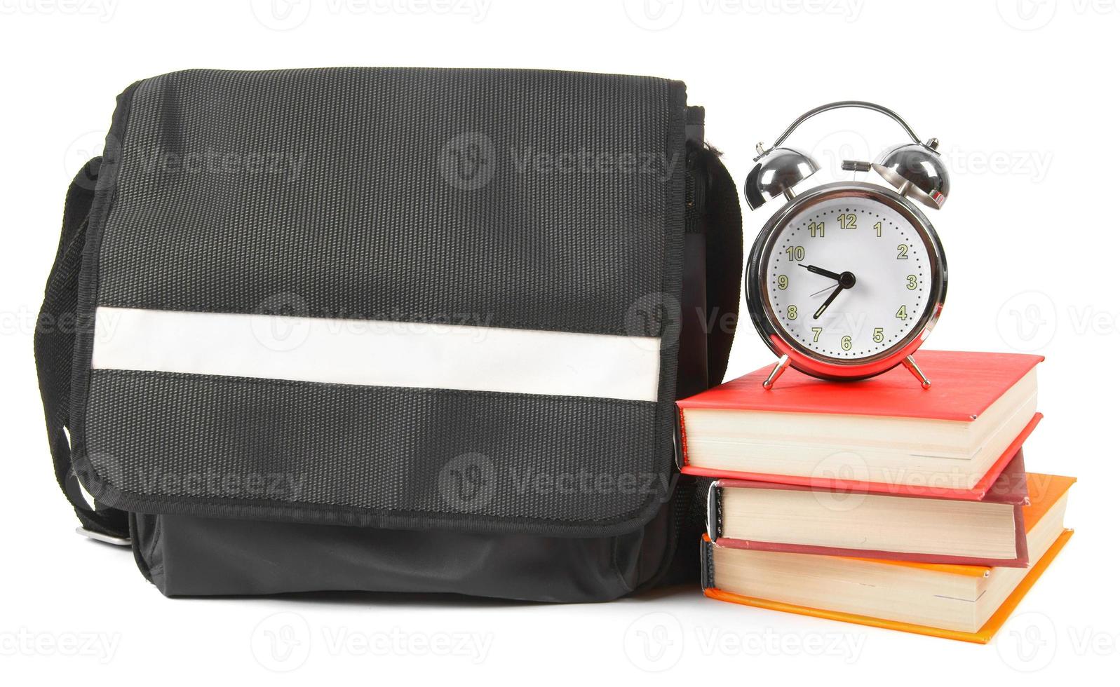 sac à dos scolaire, livres et réveil. photo