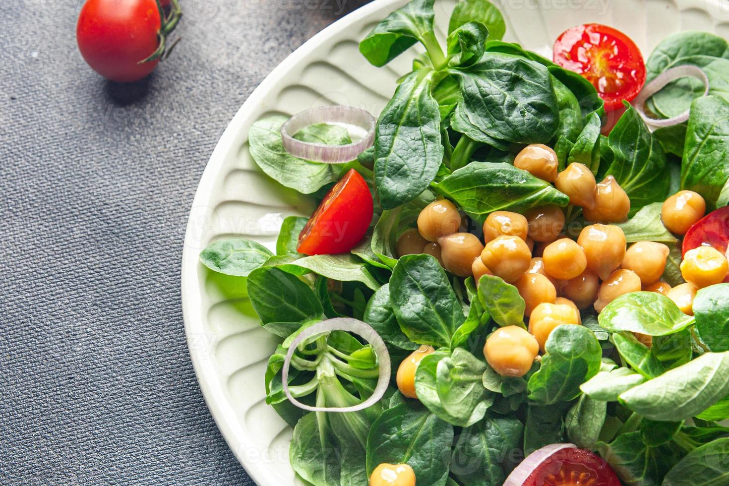 Salade de pois chiches, légumineuses, laitue, mâche, tomate repas frais et sain nourriture collation régime alimentaire sur la table copie espace arrière-plan alimentaire rustique vue de dessus régime céto ou paléo végétarien végétalien ou végétarien photo