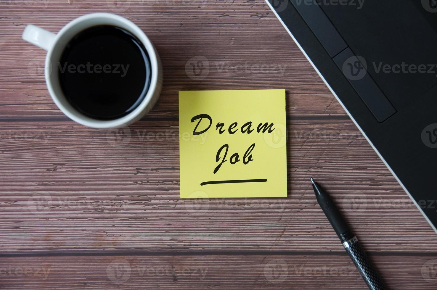 vue de dessus d'une tasse à café et d'un ordinateur portable avec bloc-notes jaune avec texte - travail de rêve. notion d'entreprise photo