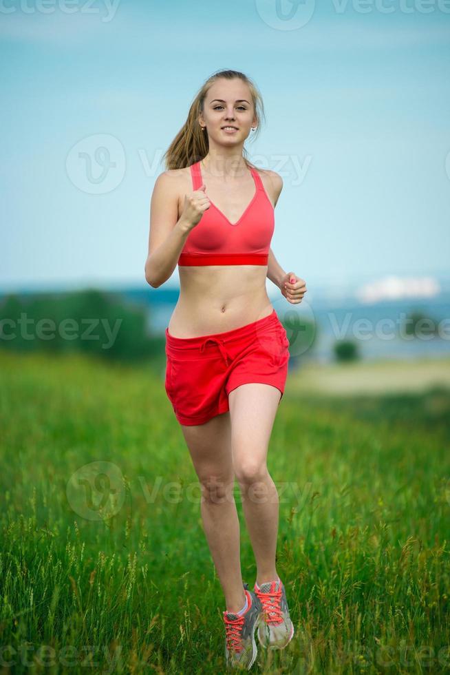 jeune femme qui court chemin rural de parc d'été exercices en plein air. j photo