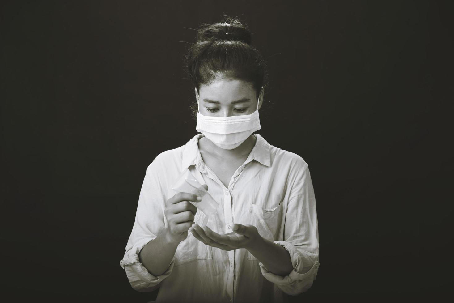 une photo d'une fille dans le studio portant un masque de protection contre le coronavirus résistant à l'infection et se nettoyant les mains avec du gel désinfectant.