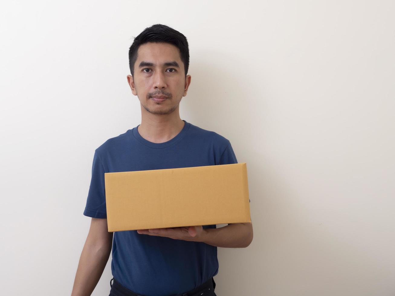 Jeune homme tenant une boîte isolé sur fond blanc photo