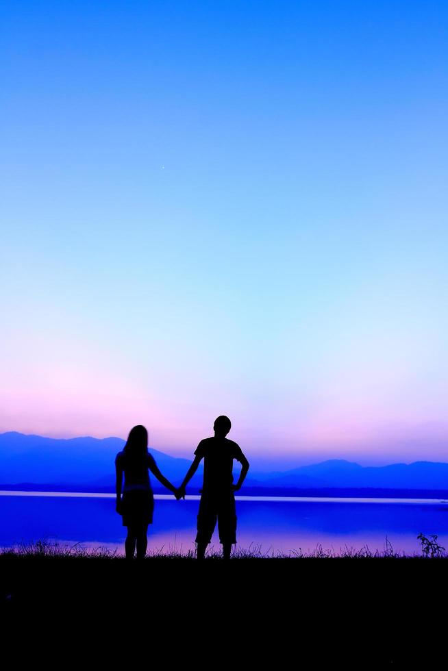 silhouette de couple au coucher du soleil photo