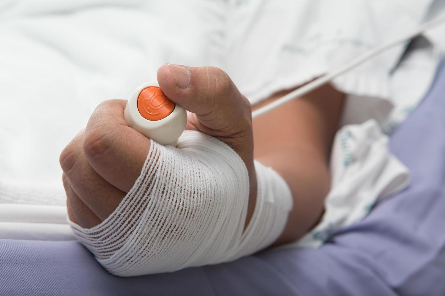 Main en appuyant sur le bouton d'appel d'infirmière d'urgence photo