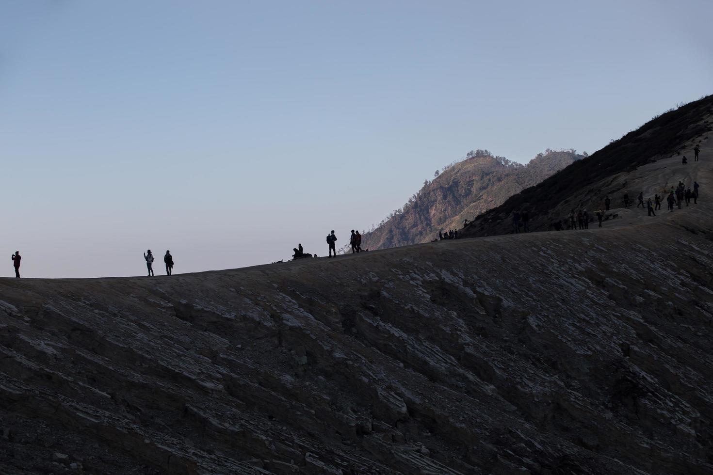 touristes en randonnée profitant de la vue du lever du soleil à java indonésie du mont ijen photo