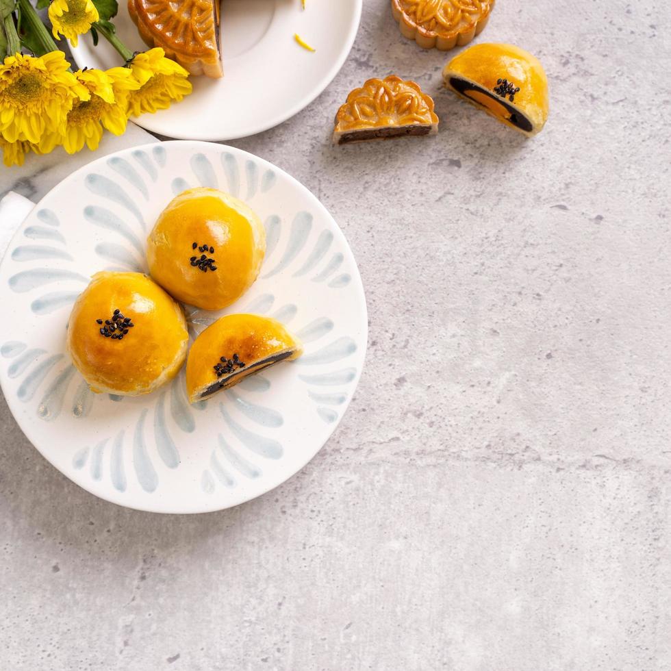 délicieux gâteau de lune de pâtisserie au jaune d'oeuf cuit au four pour le festival de la mi-automne sur fond de table en ciment brillant. concept de cuisine traditionnelle chinoise, gros plan, espace de copie. photo