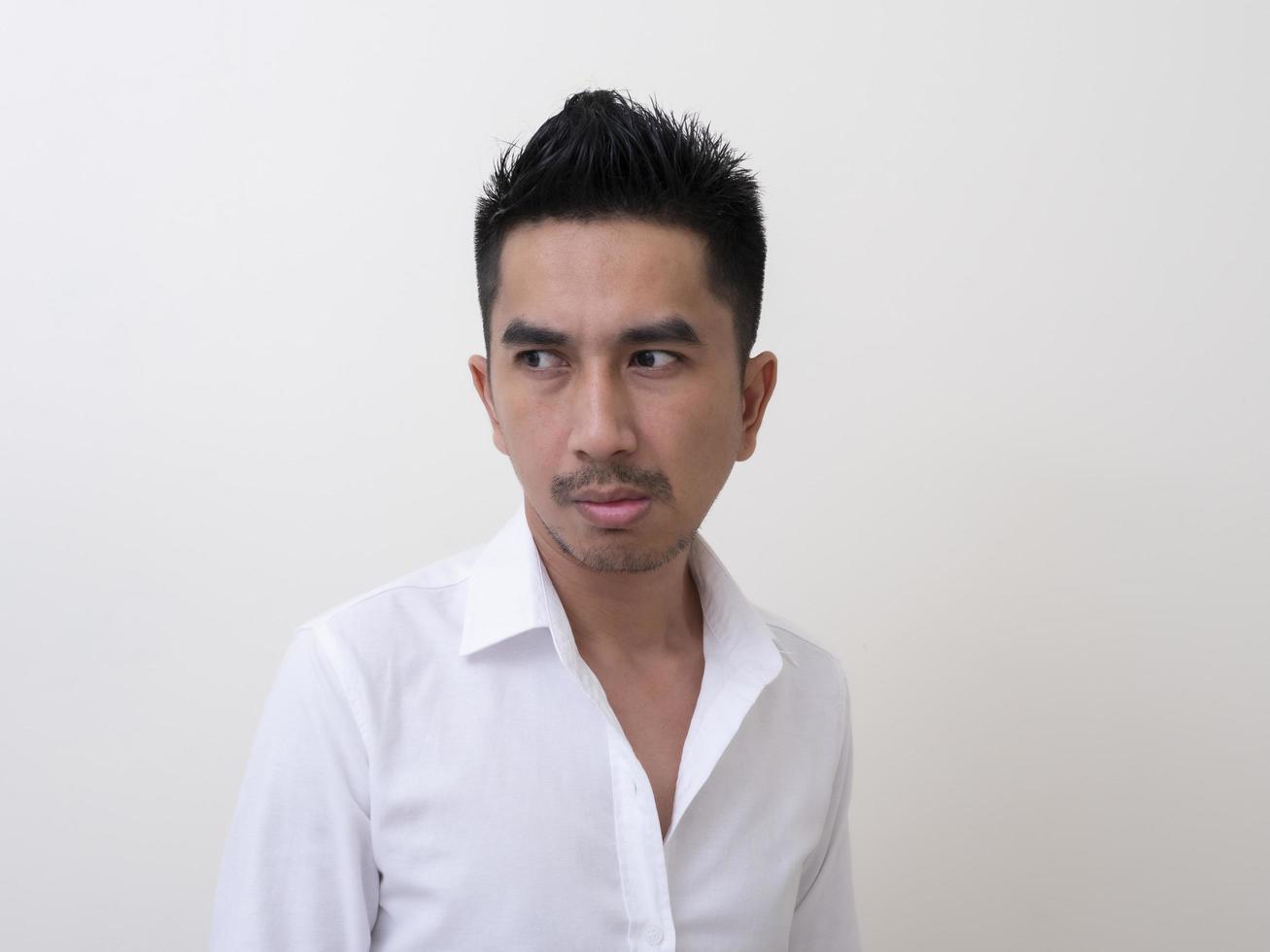 jeune homme asiatique isolé sur fond blanc regardant de côté photo