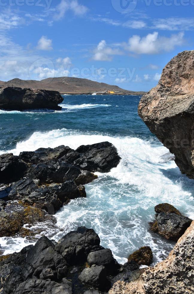 eau tourbillonnant autour des roches de lave à aruba photo